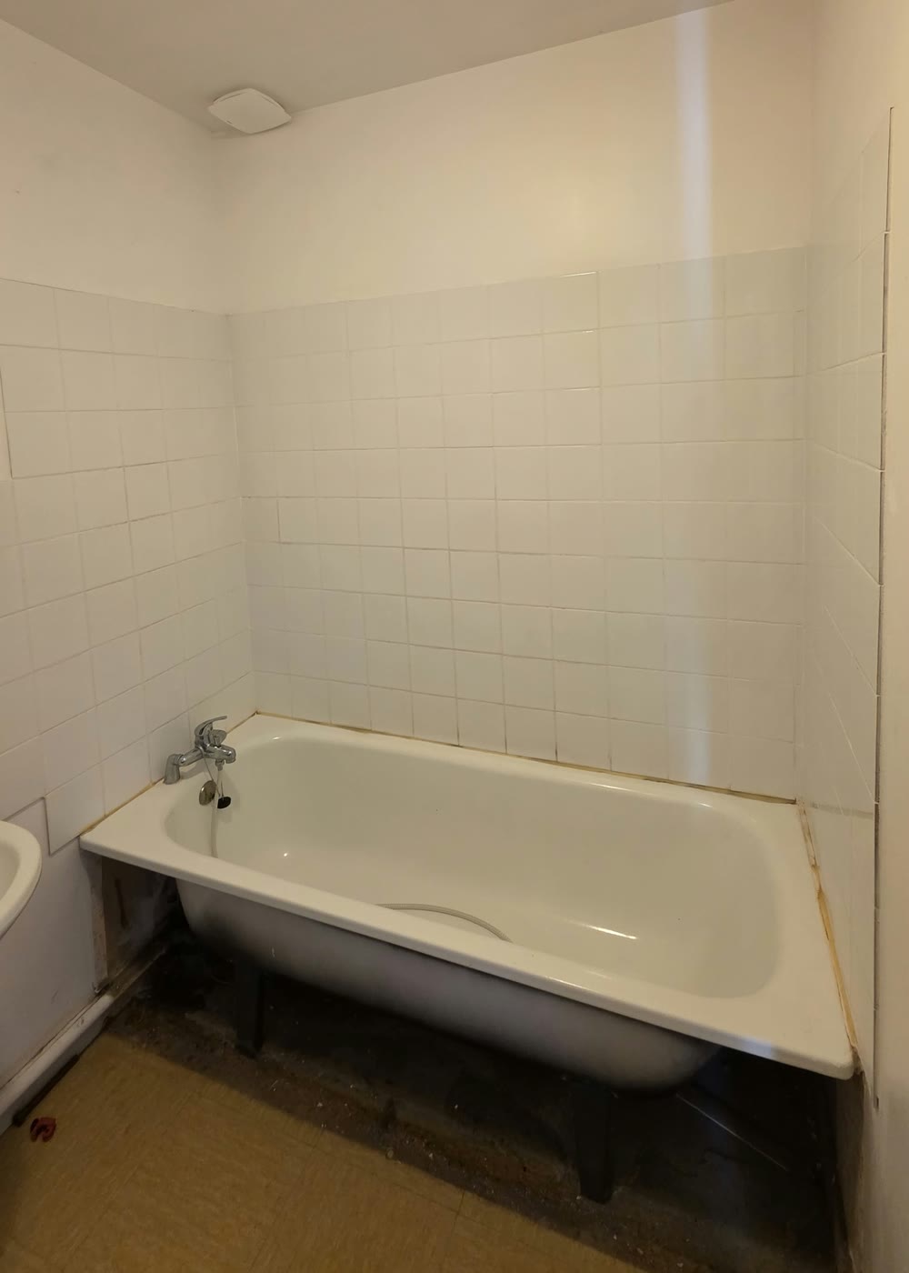 Avant — salle de bain avec ancienne baignoire et carrelage blanc